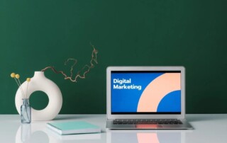 A laptop on a white table, ‘digital marketing’ written on its screen